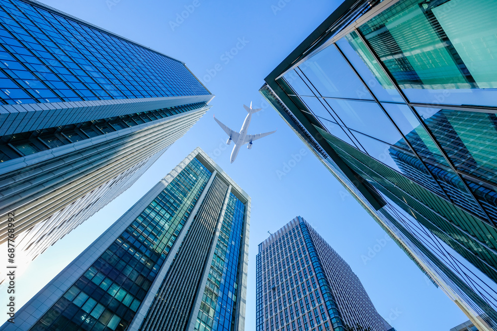 Fototapeta premium 東京のビル上空を飛行する飛行機