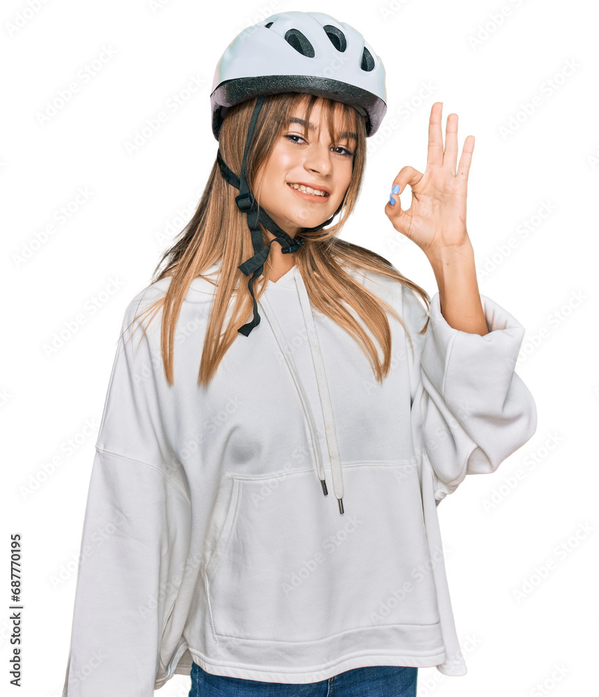 Teenager caucasian girl wearing bike helmet smiling positive doing ok sign with hand and fingers. successful expression. Teenager caucasian girl wearing bike helmet smiling positive doing ok sign with hand and fingers. successful expression.