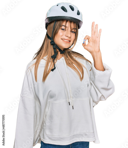 Teenager caucasian girl wearing bike helmet smiling positive doing ok sign with hand and fingers. successful expression. © Krakenimages.com