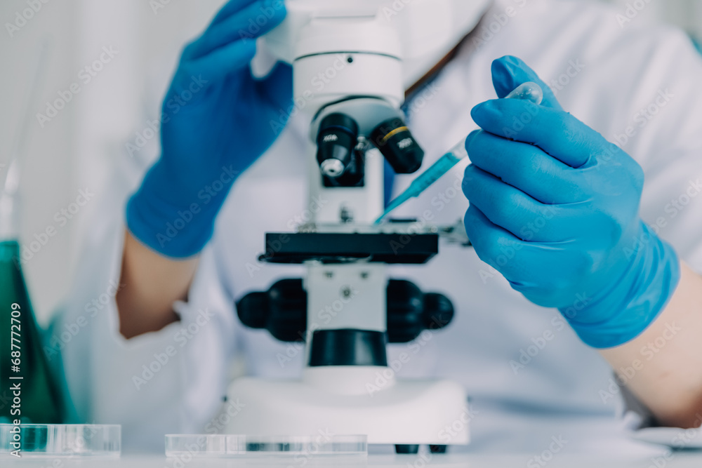 biochemical research scientist team working with microscope for coronavirus vaccine development in pharmaceutical research labolatory, selective focus biochemical research scientist team working with microscope for coronavirus vaccine development in pharmaceutical research labolatory, selective focus