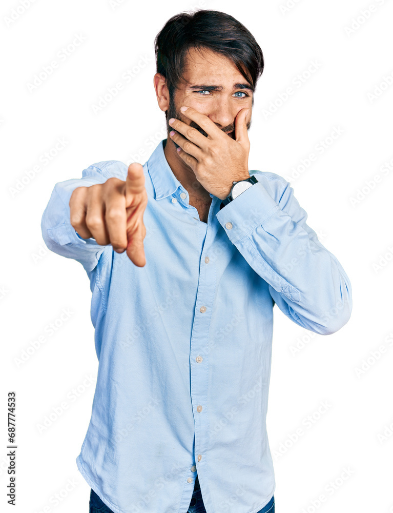 Hispanic man with blue eyes wearing business shirt laughing at you, pointing finger to the camera with hand over mouth, shame expression Hispanic man with blue eyes wearing business shirt laughing at you, pointing finger to the camera with hand over mouth, shame expression