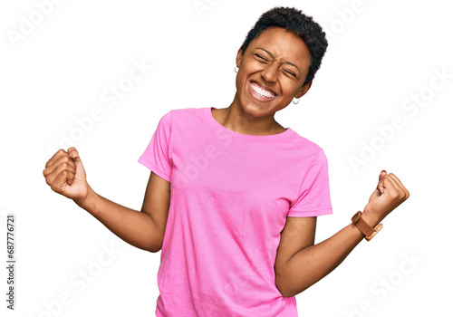 Young african american woman wearing casual clothes very happy and excited doing winner gesture with arms raised, smiling and screaming for success. celebration concept. photo