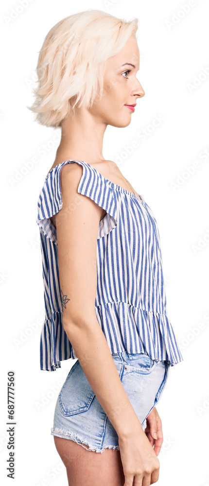 Young blonde woman with tattoo wearing casual clothes looking to side, relax profile pose with natural face with confident smile. Young blonde woman with tattoo wearing casual clothes looking to side, relax profile pose with natural face with confident smile.