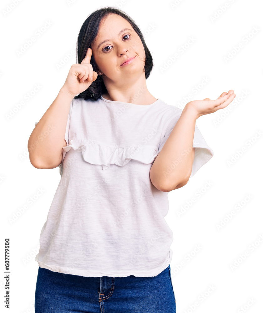 Brunette woman with down syndrome wearing casual white tshirt confused and annoyed with open palm showing copy space and pointing finger to forehead. think about it. Brunette woman with down syndrome wearing casual white tshirt confused and annoyed with open palm showing copy space and pointing finger to forehead. think about it.