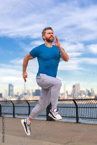 Run and jump. Runner. Running man run jog outside. Mature man runner. Fitness sport model run and training outdoor near Manhattan in New York City. Millennial athlete jogging training outdoors. Fast