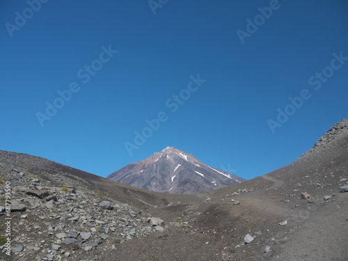 Koryaksy volcano view from Avachinsky pass on sunny day with clear blue sky and hicking trail, famous Kamchatka travel destination