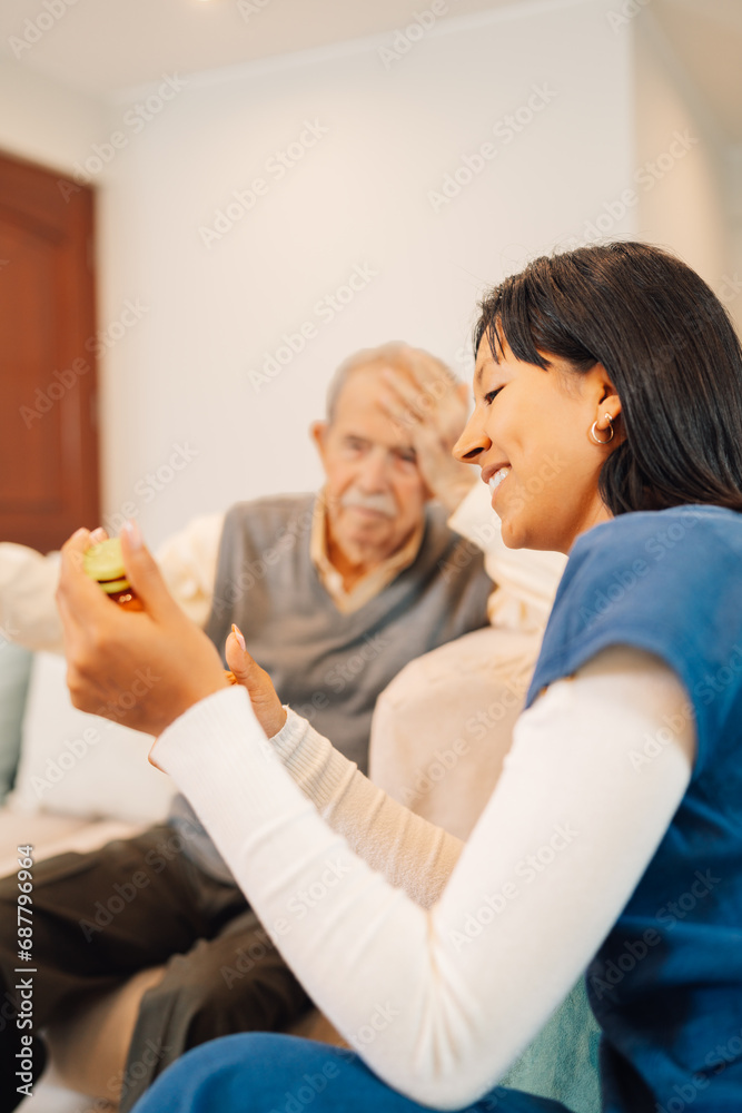 Fototapeta premium Hispanic home health care nurse talks with senior patient