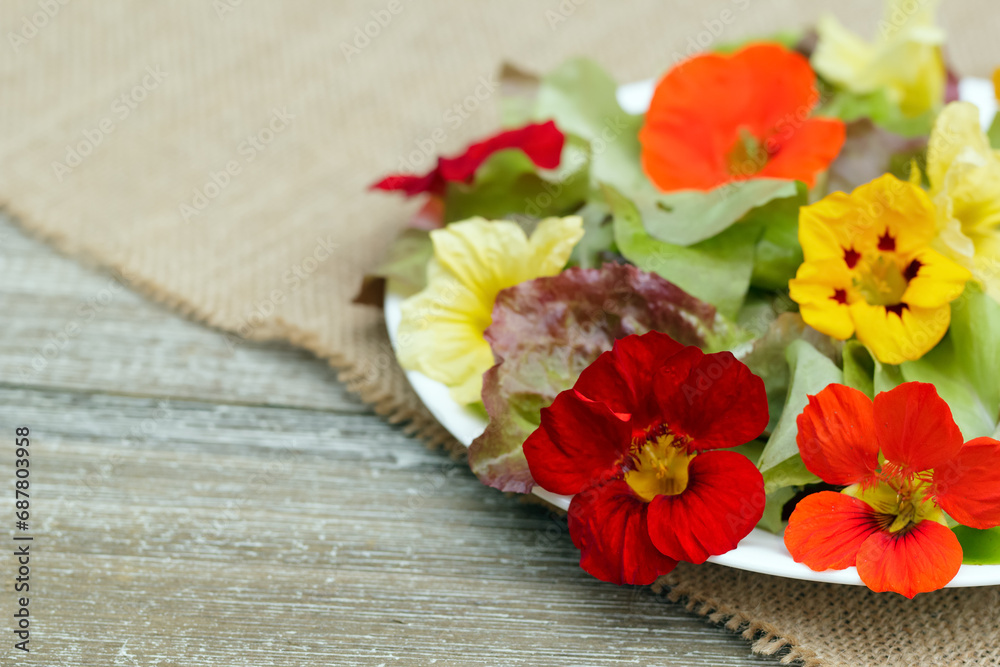 Seasonal salad of nasturtium flowers and lettuce on the wooden table. Seasonal salad of nasturtium flowers and lettuce on the wooden table.