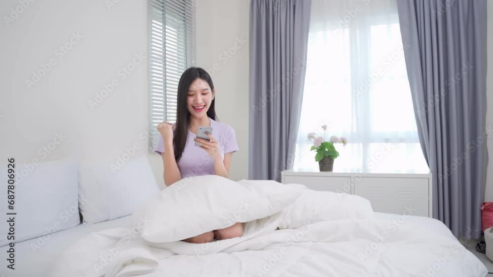 Asian woman happy and cheerful while using smartphones and working. Young businesswoman using apps on cell phones, reading news, fast connection Asian woman happy and cheerful while using smartphones and working. Young businesswoman using apps on cell phones, reading news, fast connection