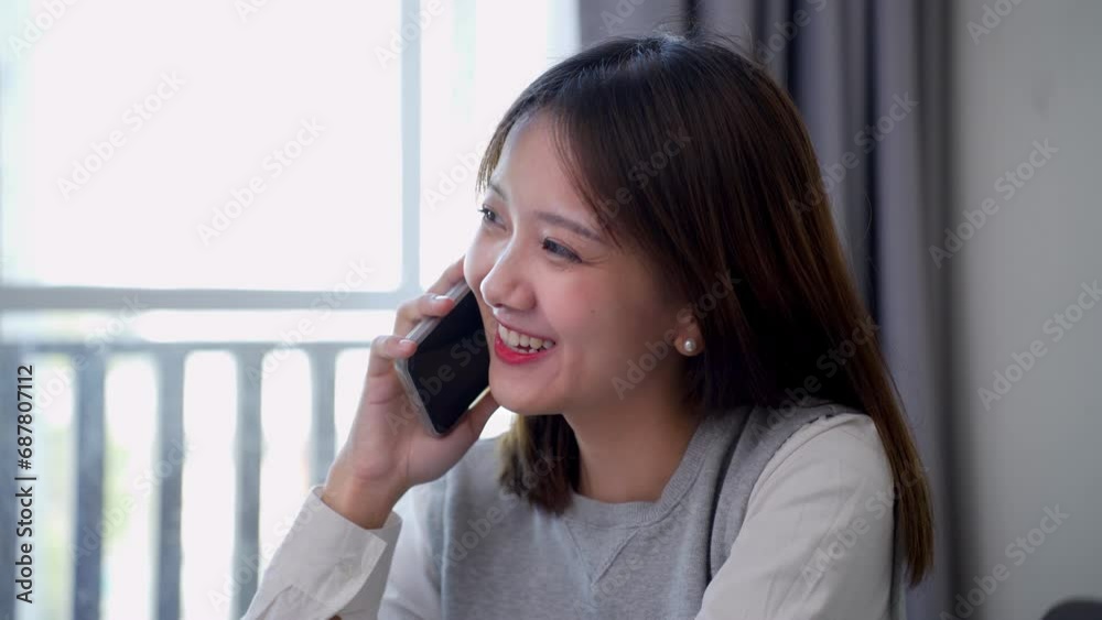 Asian woman happy and cheerful while using smartphones and working. Young businesswoman using apps on cell phones, reading news, fast connection Asian woman happy and cheerful while using smartphones and working. Young businesswoman using apps on cell phones, reading news, fast connection