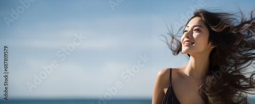 リゾート旅やヨガを連想させる日焼けや紫外線も厭わない海で太陽光を浴びるヘルシーな女性イメージ_コピースペースあり photo