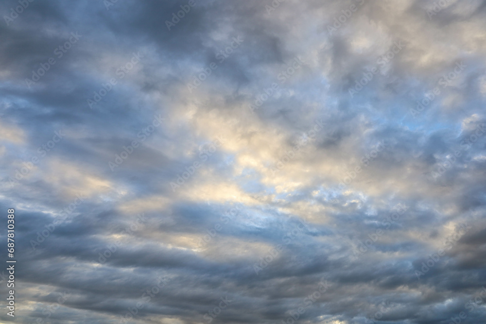 Clouds in the sky with evening light. Background image of evening sunlight shining in the middle of beautiful blue and gray clouds that look unusual with copy space. Selective focus
