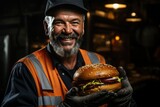 A miner holds a huge burger in his hands in a mine, lunch break for miner workers.