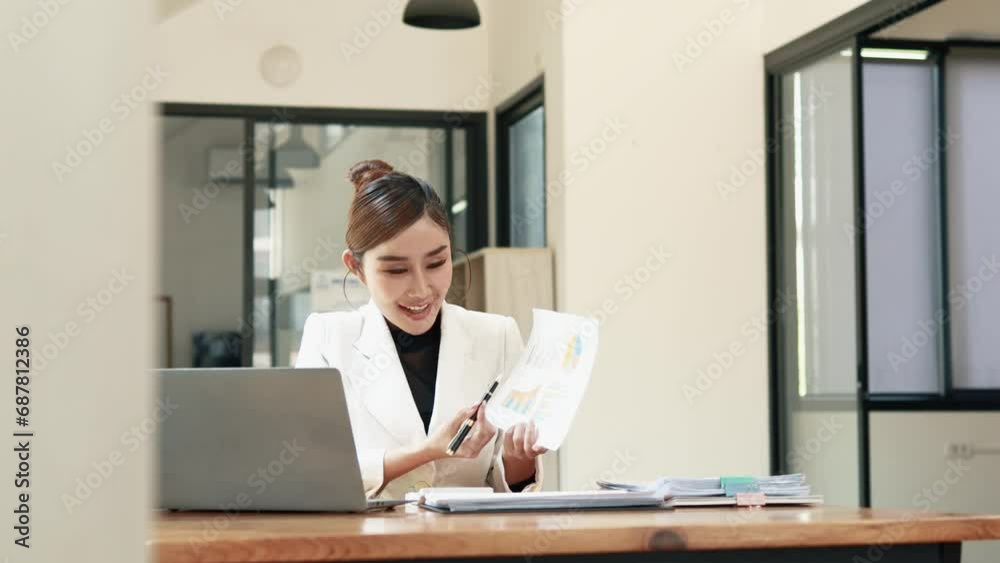 Asian woman sitting in a corporate office, business woman working, finance and accounting employees preparing financial statements, money management of a startup company. Asian woman sitting in a corporate office, business woman working, finance and accounting employees preparing financial statements, money management of a startup company.