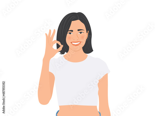 Beautiful young woman smiles happily and shows OK sign on her hand
