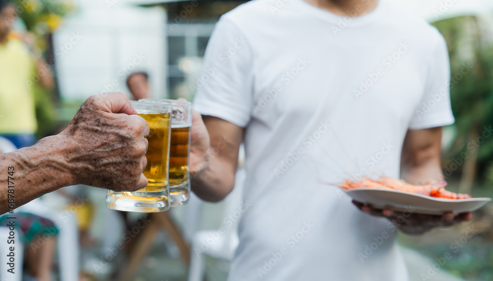 Outdoor barbecue with various meats on grill, two people holding plates and drinks, smoke rising, festive and casual atmosphere. holding glass of beer. family party. Outdoor barbecue with various meats on grill, two people holding plates and drinks, smoke rising, festive and casual atmosphere. holding glass of beer. family party.