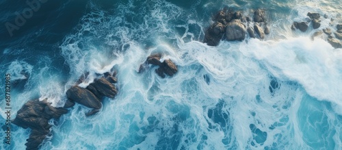 Aerial drone captures beautiful rocky shore with rolling ocean waves from above.