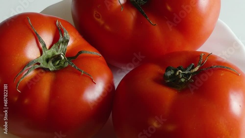 Close-Up of Ripe Tomatoes Rotating on a White Plate