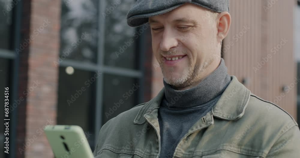 Happy young person messaging with smartphone laughing checking social media content online standing outdoors in city. Gadgets and urban lifestyle concept. Happy young person messaging with smartphone laughing checking social media content online standing outdoors in city. Gadgets and urban lifestyle concept.
