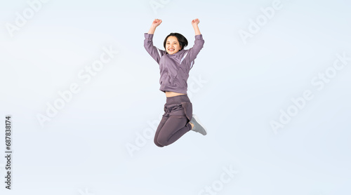 ジャンプするスポーツウェアを着た女性　切り抜き全身写真（切り抜き背景透過PNGも販売しております。作成者リンクから「PNG」で検索してください） © metamorworks