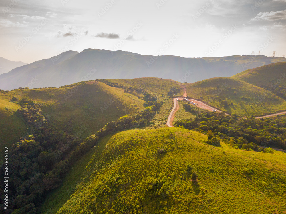 Fototapeta premium aerial view on the peak in sunset the village far from civilization Traveling on a difficult road. Beautiful sunset view on the hilltop complex. The sun shone through mountain peak after mountain.