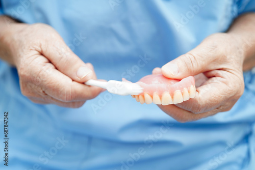 Doctor clean teeth denture with toothbrush for teach patient and dentist studying about dentistry.