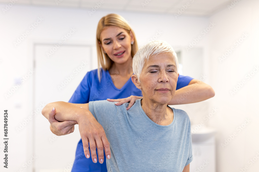 Obraz premium Female Physiotherapist working examining treating injured arm of senior female patient, stretching and exercise, Doing the Rehabilitation therapy pain in clinic.