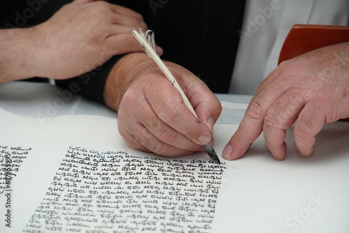 hand writing of a Jewish Torah scroll with a quill or feather according to ancient Jewish tradition.	