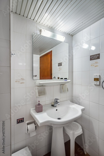 Minimalist Elegance  Simple Bathroom Interior with White Tiles  Sink  and Square Mirror. Perfect for home decor magazines  interior design projects  or any creative endeavor 