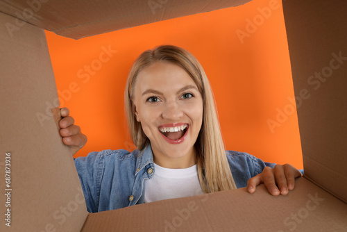 An attractive blonde looks into a cardboard box