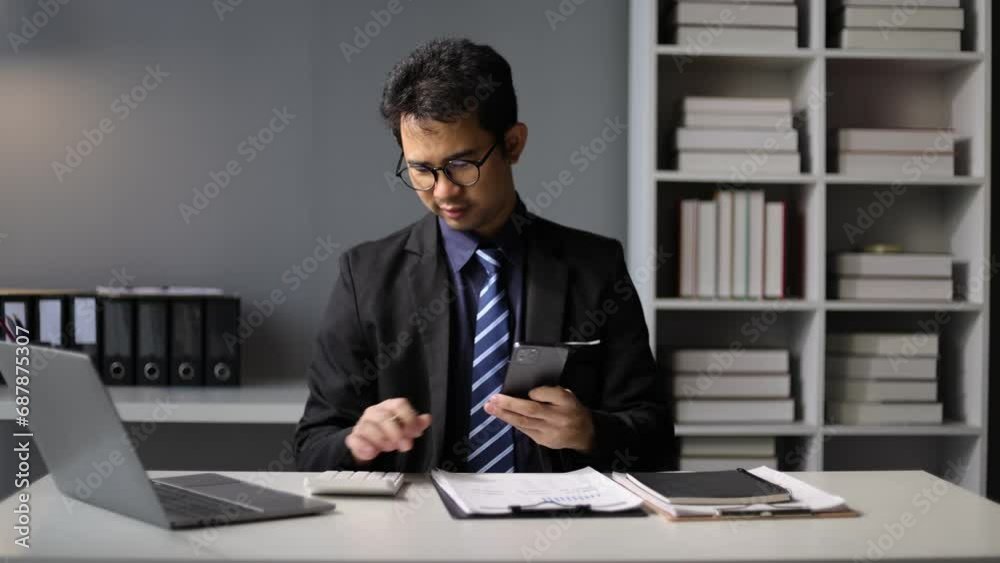 Businessman in the office is reading work documents, checking documents on the desk. Businessman working on a desk in the office. Businessman in the office is reading work documents, checking documents on the desk. Businessman working on a desk in the office.