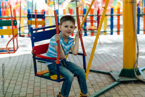 rides children's swing boy rides on a merry-go-round