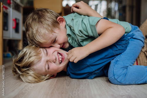 Obraz na plátne Two little boys fighting on the floor, brothers having fun at home