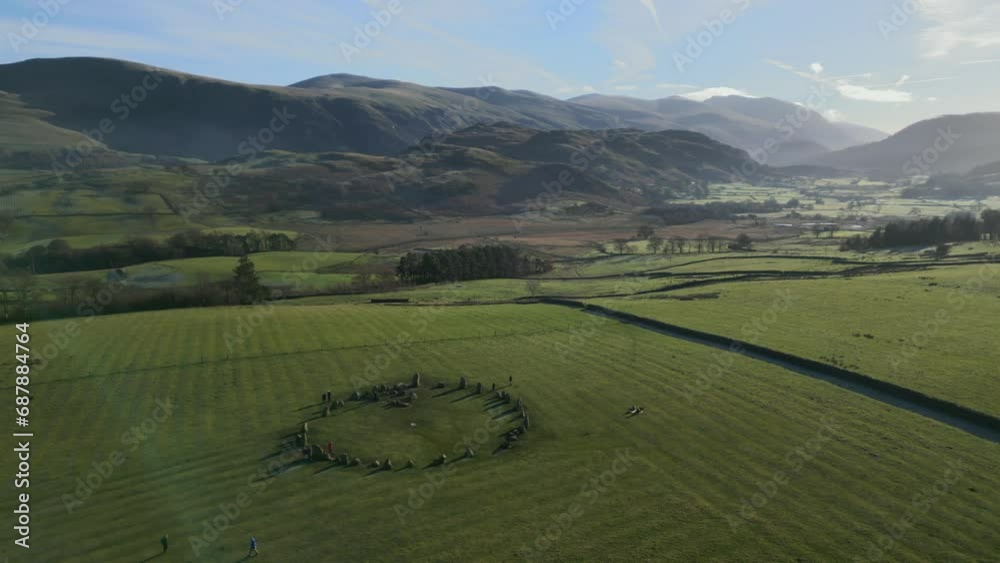 Ancient stone circle in field with orbit revealing mountains and misty valley on autumn morning at Castlerigg Stone Circle, English Lake District National Park, Cumbria, UK. Ancient stone circle in field with orbit revealing mountains and misty valley on autumn morning at Castlerigg Stone Circle, English Lake District National Park, Cumbria, UK.