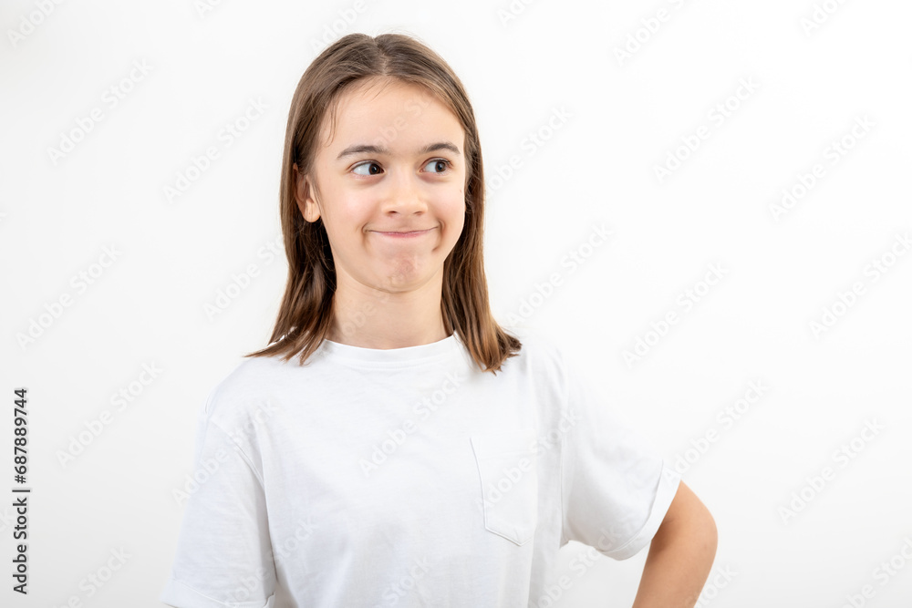 Little girl looks to the side in surprise on a white background isolated. Little girl looks to the side in surprise on a white background isolated.