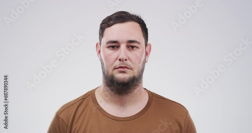 Serious man, face and beard with blank stare standing isolated against a studio background. Portrait of jewish or caucasian male person or casual model looking with no expression on mockup space