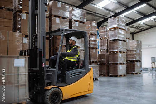 Multiracial warehouse worker driving forklift. Warehouse worker preparing products for shipmennt, delivery, checking stock in warehouse. © Halfpoint
