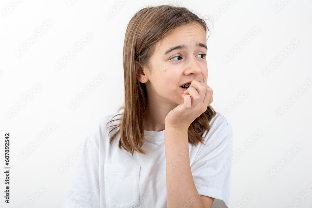 Scared and anxious girl, biting her fingernails on a white background isolated. Scared and anxious girl, biting her fingernails on a white background isolated.