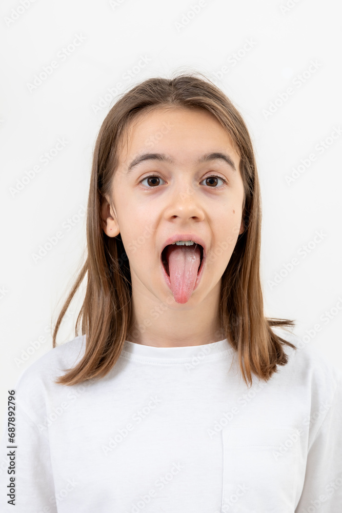 Portrait of a teenage girl showing her tongue isolated on a white background. Portrait of a teenage girl showing her tongue isolated on a white background.