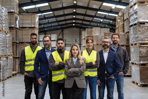 Full team of warehouse employees standing in warehouse. Team of workers, managers, female director in modern industrial factory, heavy industry, manufactrury. photo