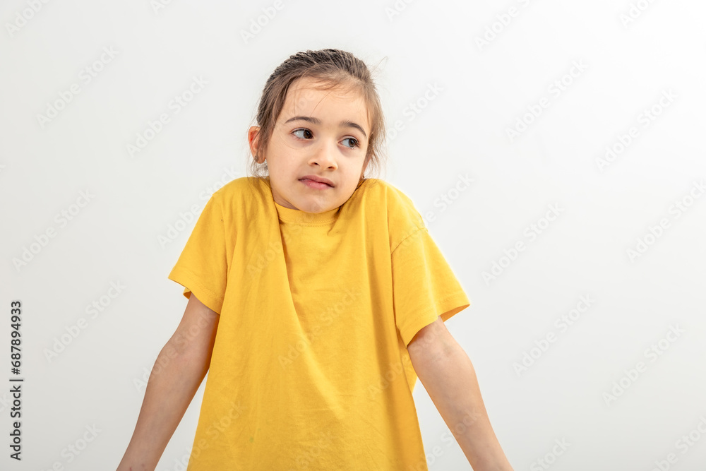 Little Caucasian girl shyly posing on white background. Little Caucasian girl shyly posing on white background.