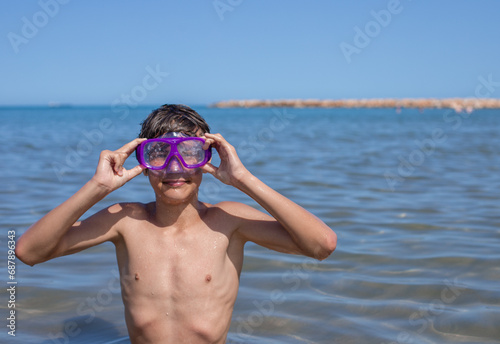Teenager exudes positivity, wearing a diving mask while enjoying the vibrant atmosphere of a summer beach.