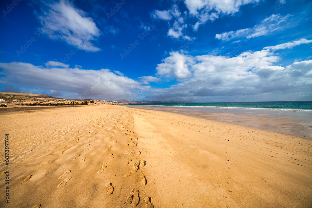 A tranquil beach with blue sky and clear water's edge. A tranquil beach with blue sky and clear water's edge.