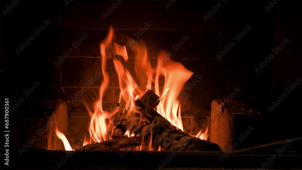 Home fireplace with red flame and firewood. 4K video relaxing endless footage