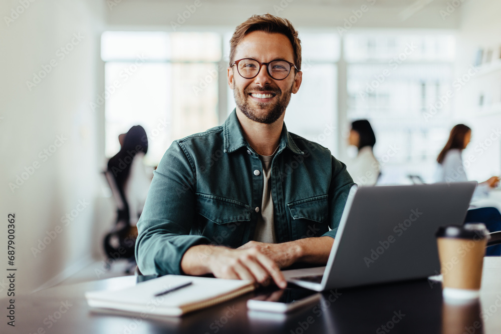 Portrait of a business man sitting in an office - obrazy, fototapety, plakaty 