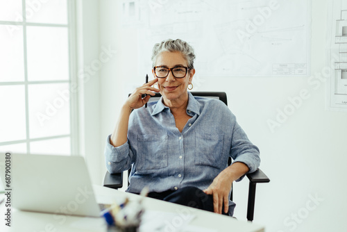 Senior graphic designer thinking carefully while sitting at her desk in an office