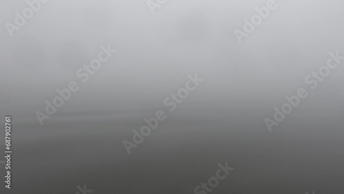 Broomes Island, Maryland USA A small motorboat advances on the Patuxent River in thick fog.  photo