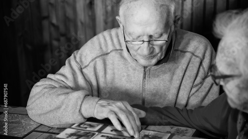 An elderly couple scrolls photos on a family album at home