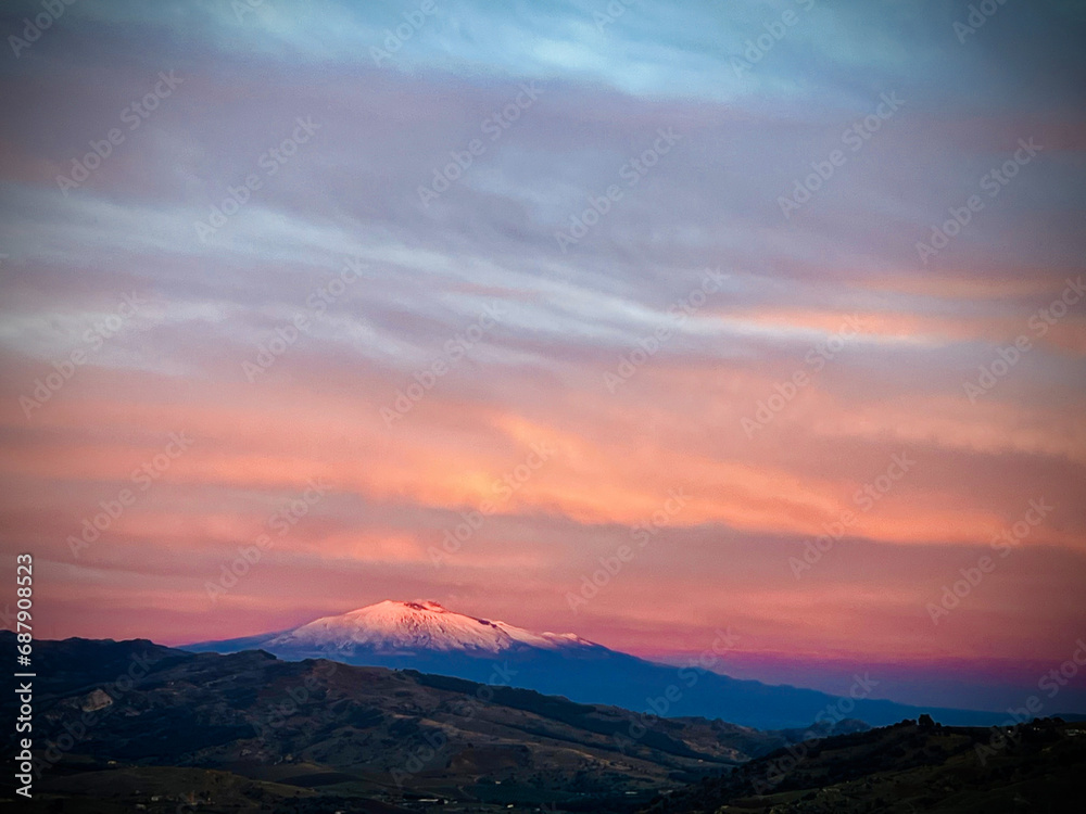 Etna imbiancata dalla neve di colore rosa al tramonto