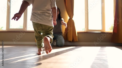 baby baby first steps. happy family a kid dream concept. child runs barefoot to mom hugs at home indoors hugs joy. baby runs to mom first steps on the floor indoors lifestyle photo